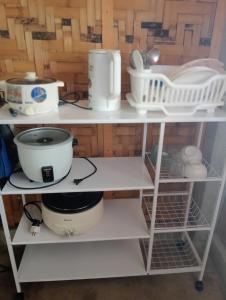 a shelf with dishes and other kitchen items on it at Kalma Kubo Siargao in San Isidro