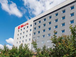 a white building with a red hotel sign on it at ibis Pelotas - Recem inaugurado in Pelotas