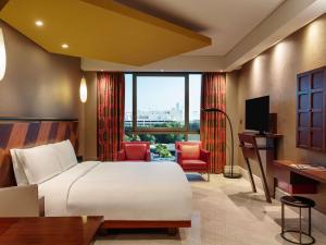 a bedroom with a bed and a desk and a television at The Creekside Hotel, Dubai - an Accor Hotel in Dubai +155 photos