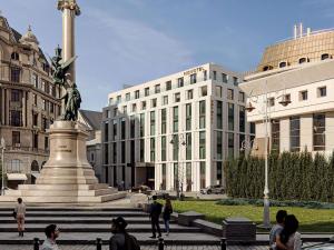 a statue in the middle of a city with buildings at Novotel Lviv Center in Lviv