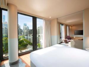 a hotel room with a large bed and large windows at Mercure Melbourne La Trobe Street in Melbourne +86 photos