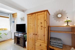 a room with a wooden cabinet and a television at Fewo Sonnenstübchen Mendig 2Pers in Mendig