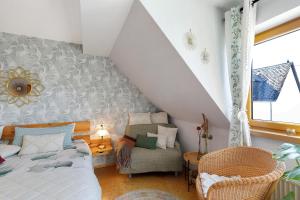 a attic room with a bed and a chair at Fewo Sonnenstübchen Mendig 2Pers in Mendig