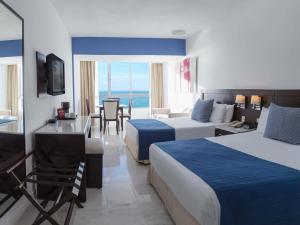 a hotel room with two beds and a table and chairs at Park Royal Mazatlán in Mazatlán