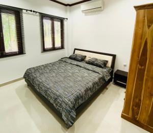 a bedroom with a bed and two pillows on it at Tha sala beach house in Ban Phang Pling