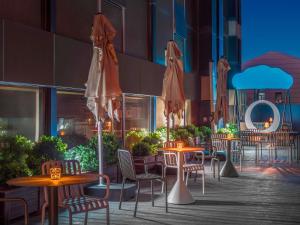 an outdoor patio with tables and chairs and umbrellas at Mercure Beijing Future Science City in Beijing