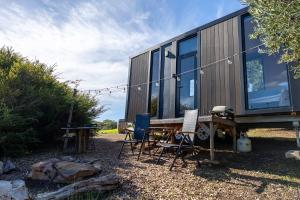 a tiny house with a picnic table and chairs at Scrub Tiny House by Tiny Away in McLaren Vale