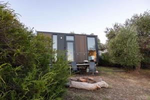 a tiny house in the woods with a table and chairs at Scrub Tiny House by Tiny Away in McLaren Vale
