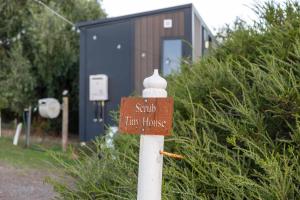 a sign on a pole in front of a tiny house at Scrub Tiny House by Tiny Away in McLaren Vale