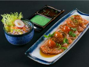 a table with a plate of food and a bowl of salad at Swissotel Jeddah Al Hamra in Jeddah