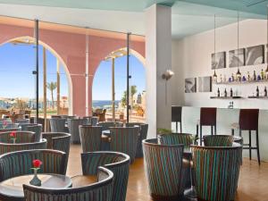 a restaurant with chairs and tables and windows at Swissotel Resort El Quseir in Quseir