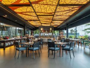 a restaurant with tables and chairs and a bar at Mercure Solo in Solo