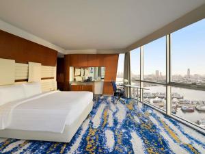 a hotel room with a bed and a large window at Mövenpick Dubai Creek in Dubai