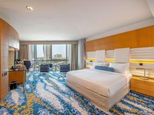 a hotel room with a large bed and a large rug at Mövenpick Dubai Creek in Dubai