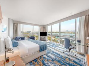 a hotel room with a large bed and a large window at Mövenpick Dubai Creek in Dubai