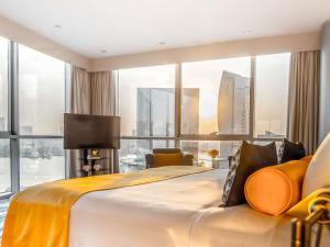 a bedroom with a large bed with a large window at Mövenpick Dubai Creek in Dubai +81 photos