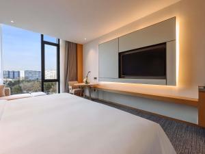 a hotel room with a large bed and a flat screen tv at MOVENPICK TASHKENT OLD CITY in Tashkent