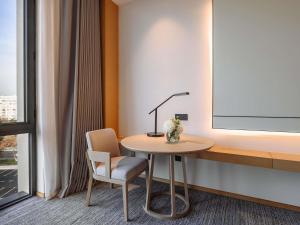a room with a table and a lamp and a chair at MOVENPICK TASHKENT OLD CITY in Tashkent