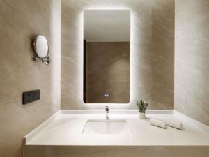 a bathroom with a white sink and a mirror at MOVENPICK TASHKENT OLD CITY in Tashkent +80 photos