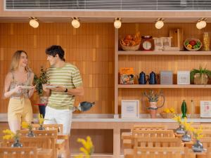 a man and a woman are standing in a kitchen at ibis Styles Phuket Bangtao in Bang Tao Beach +114 photos