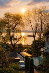 a sunset over a body of water with trees at Heritage Rose Inn in Srinagar +31 photos
