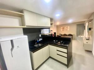 a kitchen with white cabinets and a black counter top at Flat FM20 Apt 401 in João Pessoa