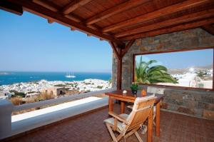 a patio with a wooden table and chairs and the ocean at Germanos Studios in Mikonos