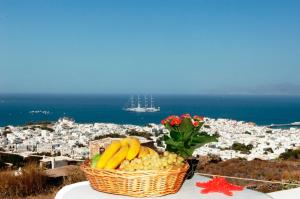 a basket of fruit on a table with a view of a city at Germanos Studios in Mikonos