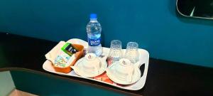 a tray with a bottle of water and plates and drinks at ANANDHA RESIDENCY in Karaikal +13 photos