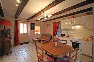 a kitchen and living room with a table and a dining room at La bachellerie in Nedde