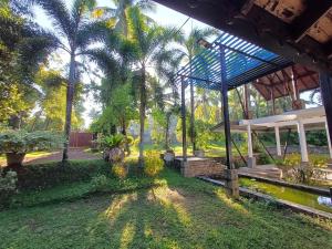 a garden with palm trees and a pavilion at Paboda Residency in Minuwangoda