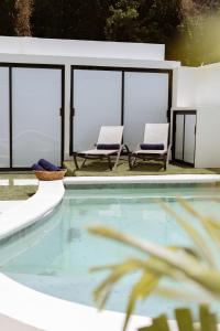 two chairs sitting next to a swimming pool at Saules Armonía in Cancún