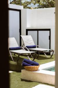 two chairs with blue cushions sitting next to a pool at Saules Armonía in Cancún