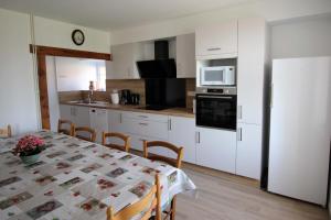 a kitchen with a table and a white refrigerator at Naugeat in La Roudie