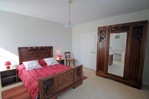 a bedroom with a bed and a large mirror at Naugeat in La Roudie