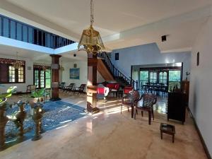 a large living room with a chandelier and chairs at Paboda Residency in Minuwangoda