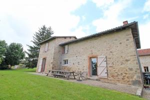 an external view of a stone building with a picnic table at Le petit feuillade in Saint-Laurent-sur-Gorre