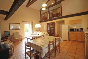 a kitchen and a living room with a table and chairs at Le petit feuillade in Saint-Laurent-sur-Gorre