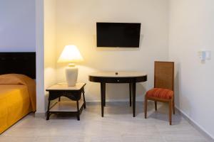 a room with a table and a chair and a bed at Saules Armonía in Cancún