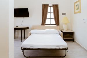 a bedroom with a bed and a desk and a television at Saules Armonía in Cancún