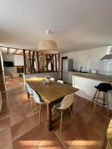 a kitchen and dining room with a wooden table and chairs at La grande ourse in Panazol