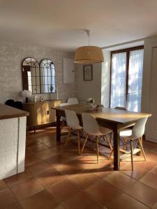 a kitchen and dining room with a wooden table and chairs at La grande ourse in Panazol +7 photos