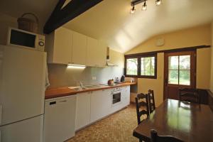 a kitchen with white cabinets and a table and a counter top at Pierre-brune in Saint-Priest-Taurion