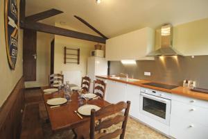 a kitchen with a wooden table and a dining room at Pierre-brune in Saint-Priest-Taurion +20 photos