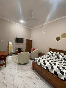 a bedroom with a bed and two chairs and a tv at Mnazinisky B&B in Zanzibar City
