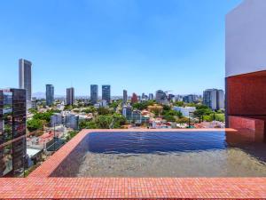 a swimming pool on top of a building with a city at Brada Collection Stays in Guadalajara