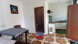 a living room with a table and a kitchen at DreamCatcher & Homestay in McLeod Ganj