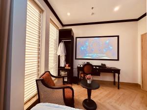a living room with a television and a table and chairs at Cera Hotel in Ho Chi Minh City +25 photos