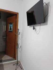 a flat screen tv hanging on a wall at Suítes Monte Cristo II in Aparecida