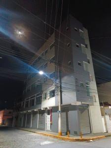 a building with a street light in front of it at Suítes Monte Cristo II in Aparecida